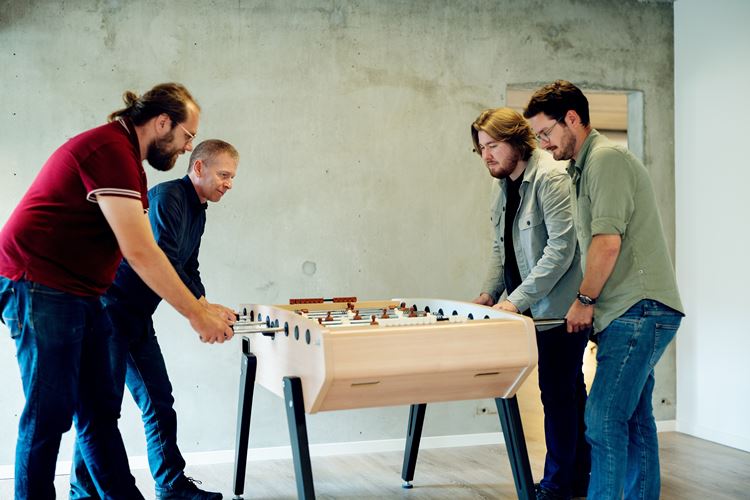Acto-medarbejdere der spiller bordfodbold i en pause