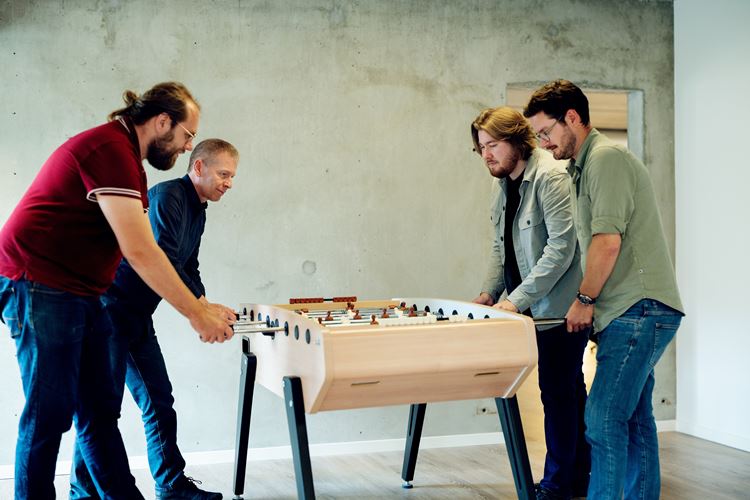 Acto-medarbejdere der spiller bordfodbold i en pause